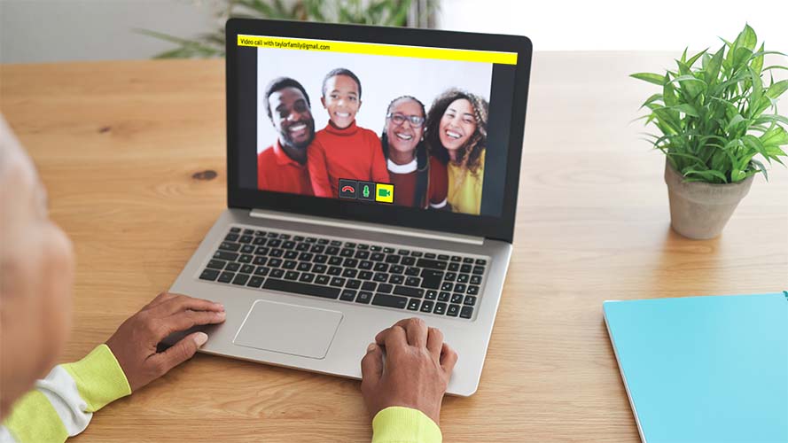 Woman using GuideConnect on a laptop to video call her family.